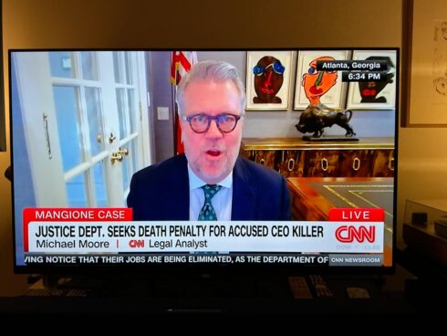 Aufnahme eines Fernsehers mit einem CNN Interview, dabei sind Bilder von Peter Robert Keil im Hintergrund zu sehen.